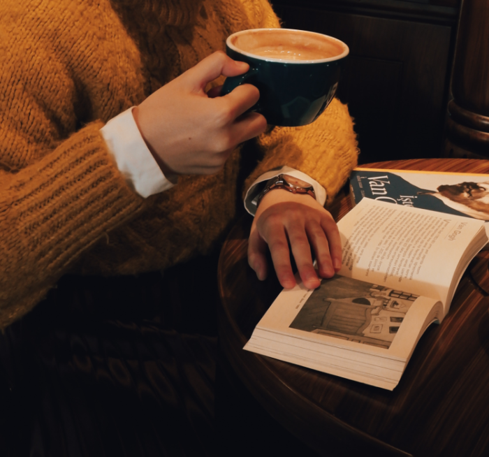 Woman with cofee reading book in a cafe (Fly into books).