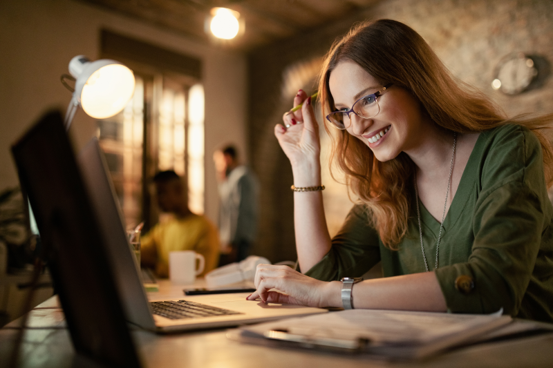 Woman Smiling while looking at a computer - Tracking Book Sales (flyintobooks.com)